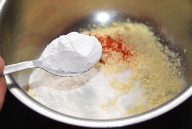 Add besan, rice flour, salt, turmeric powder, red chilli powder, salt, hing, water mix well