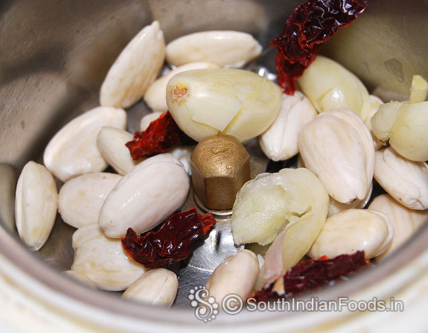In a mixie jar add, soaked almond, dry red chilli & garlic, grind to smooth paste