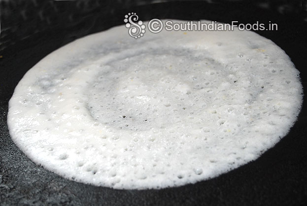 Heat iron dosa tawa, pour dosa batter, spread immediately