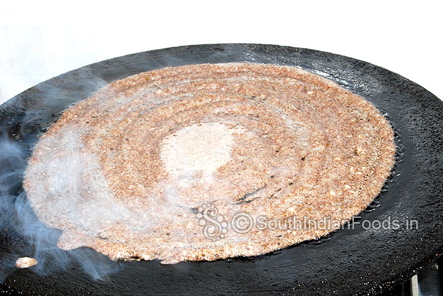Pour 1 tbsp of oil around the dosa, cover it & cook both sides