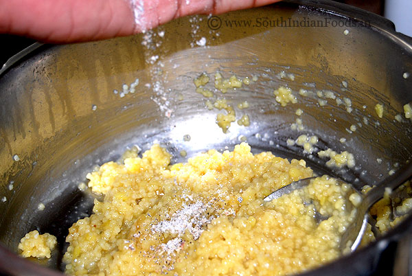 Adding cardamom powder to thinai rice mixture