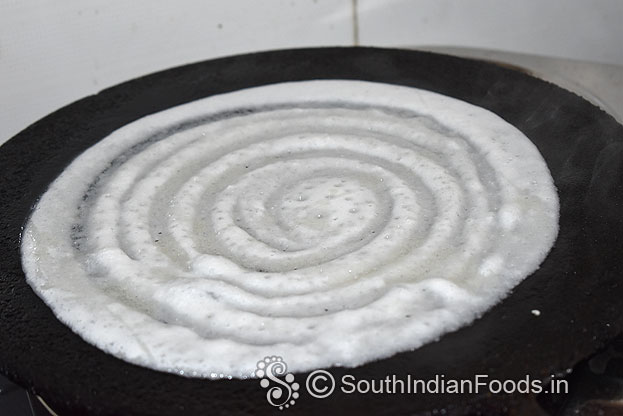 Heat iron dosa tawa, pour batter, evenly spread