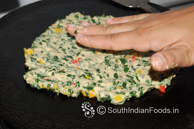 Heat iron dosa tawa,  place one handful of dough, evenly spread