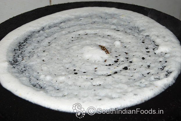 Heat iron dosa tawa, pour batter, spread evenly