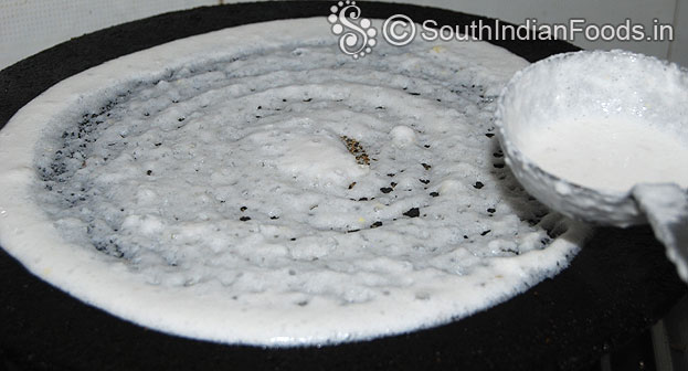 Heat iron dosa tawa, pour batter, spread evenly