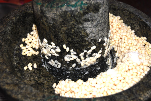 Grind soaked urad dal in stone mortar