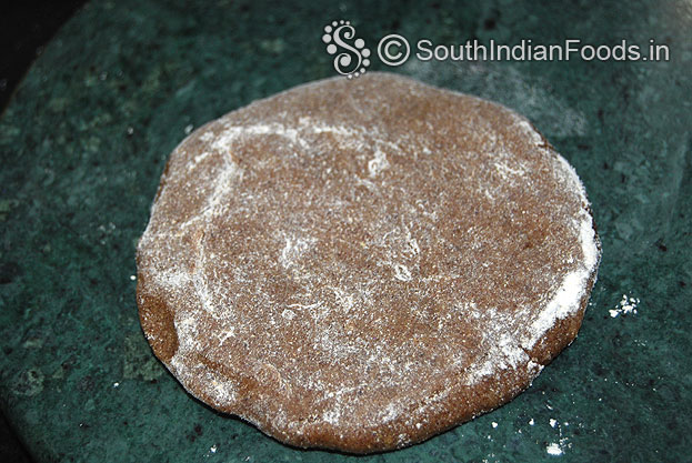 Sprinkle flour over the ragi chapati