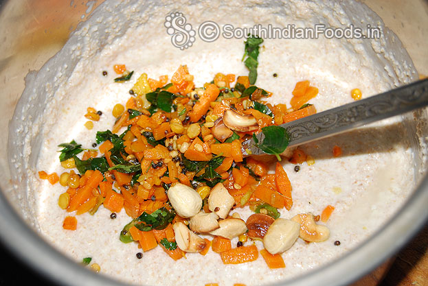 In a bowl add dry roasted wheat rava, salt, curd, & water leave it for 2 hours then add seasoned ingredients, asafetida mix well.