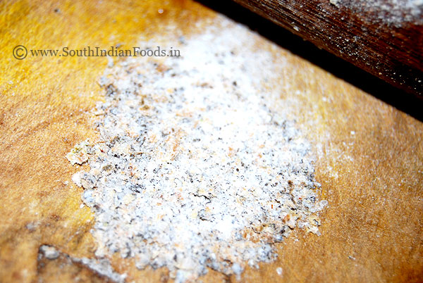 Manually grinding cardamom powder