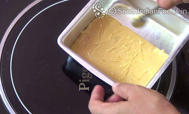 Transfer mixture to the ghee greased tray, spread immediately