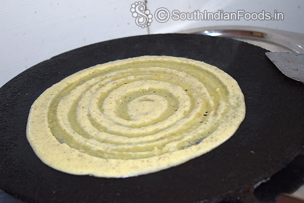 Heat iron dosa taw, pour batter, evenly spread