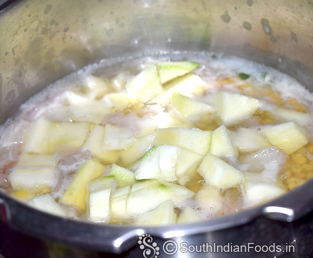 In a pressure cooker, Add toor dal, mango, onion, garlic, green chilli