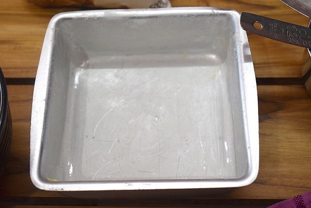 Grease tray with butter then sprinkle flour coat well