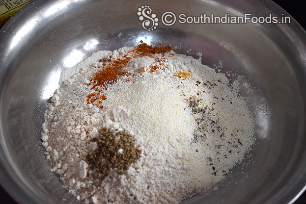 In a bowl add wheat flour, rava, carom seeds, turmeric ,red chilli powder, crushed pepper